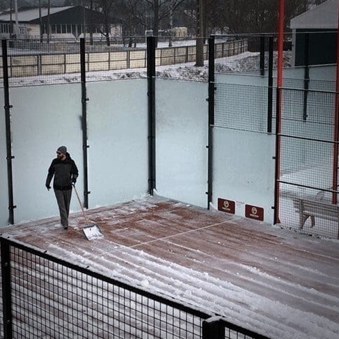 Snow-covered padel court without a Courtcovers Padel Court Cover, showing the labor required to clear the snow and the need for all-weather protection to safeguard the padel carpet. Alpa-Management